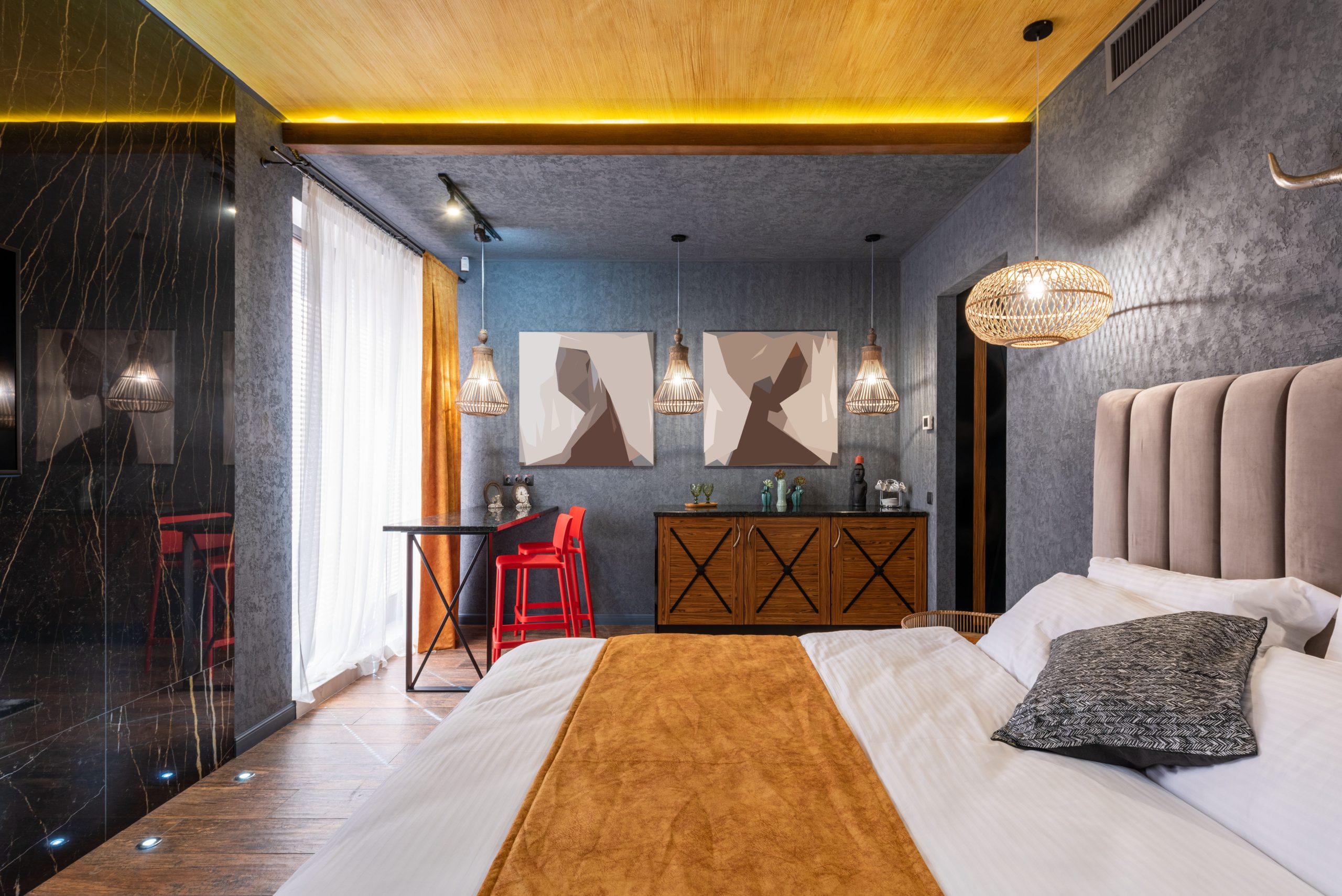 Stylish interior design of contemporary bedroom with cozy king size bed high table and cabinets under creative chandeliers
