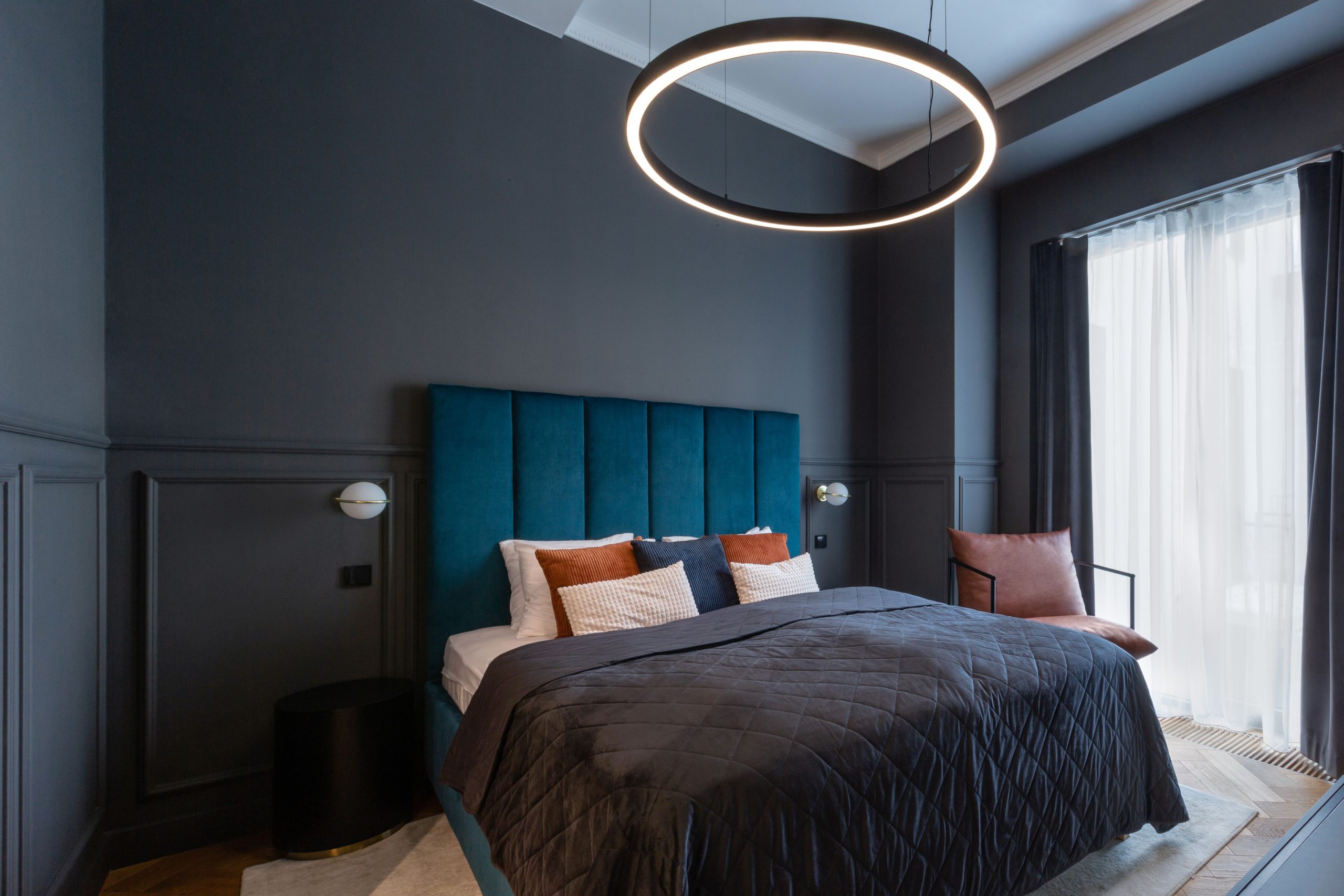 Stylish modern bedroom in Prague featuring a contemporary ring light and cozy bedding.